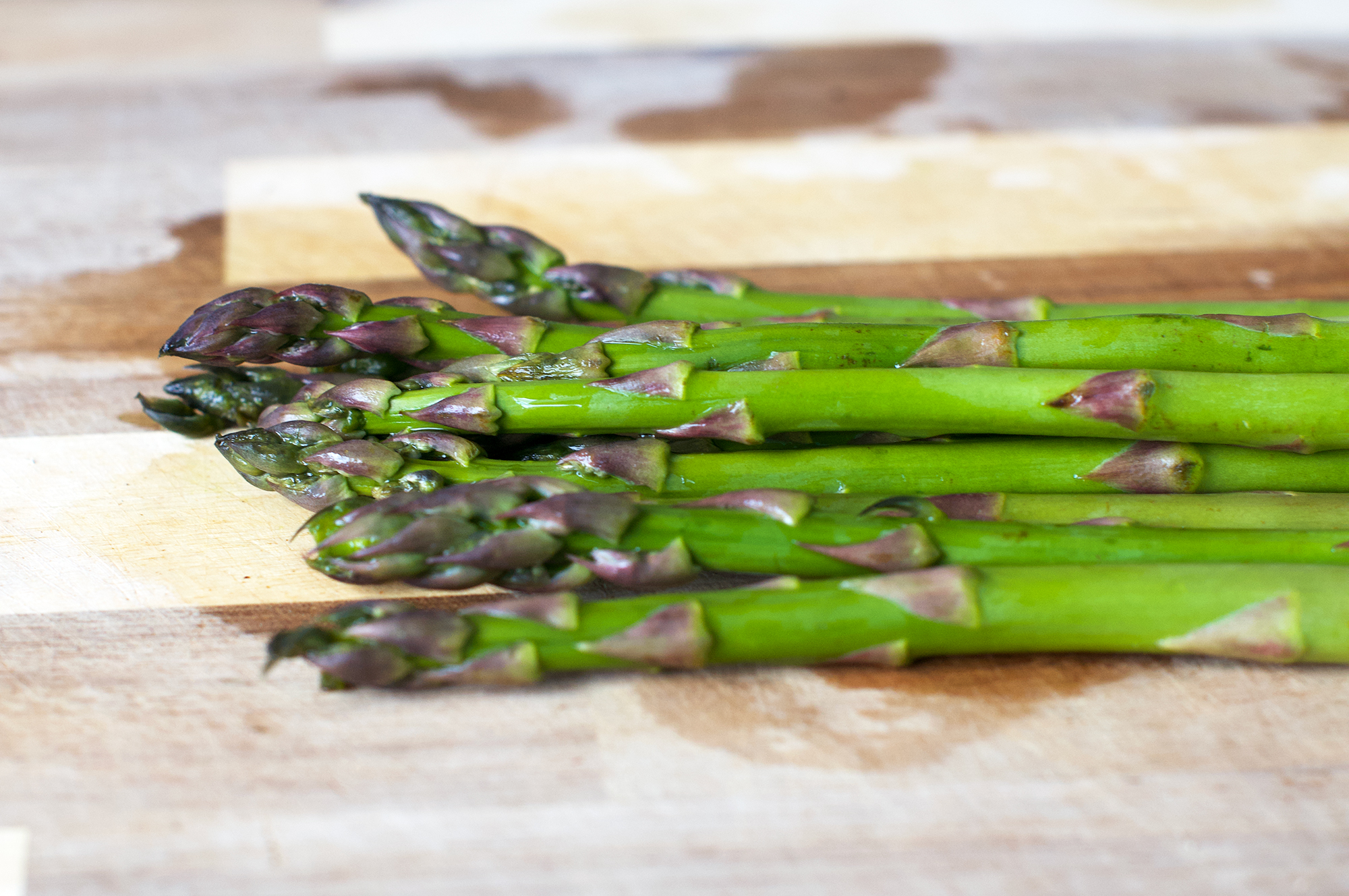 Fresh British green asparagus on chopping board