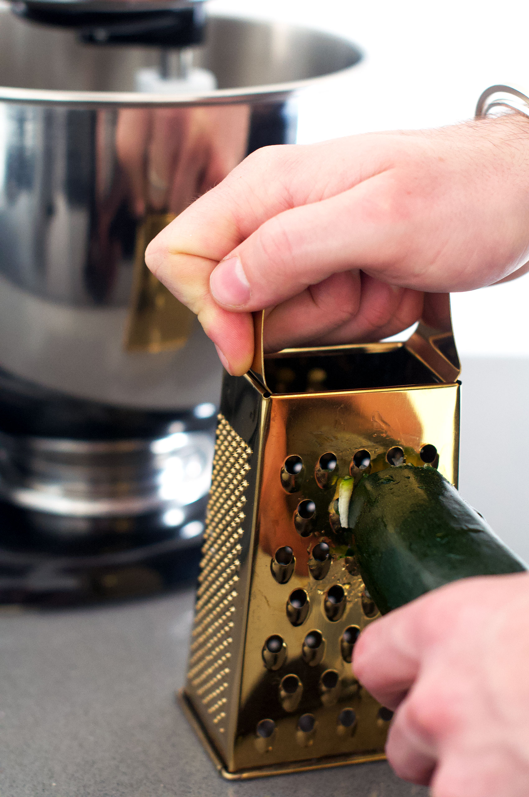 Grating courgette using a golden four-sided box grater